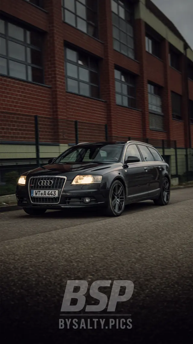 Schwarzer Audi A6 Avant vor einem Backsteingebäude