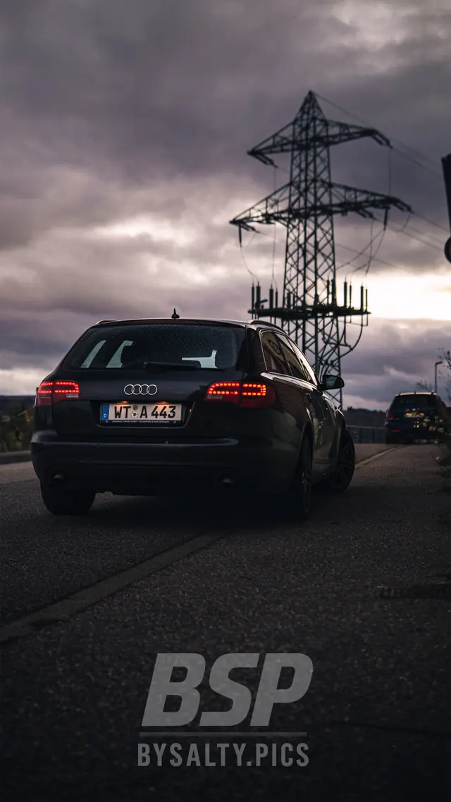 Audi A6 Avant von hinten vor einem Strommast und dunklen Wolken