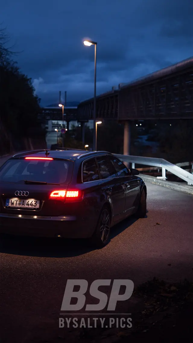 Audi A6 Avant von hinten bei Dämmerung mit roten Rücklichtern