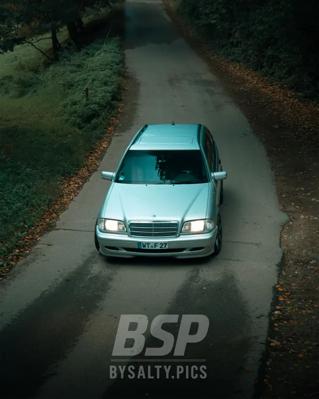 Mercedes C-Klasse T-Modell auf einer Waldstraße mit Herbstlaub, von oben fotografiert